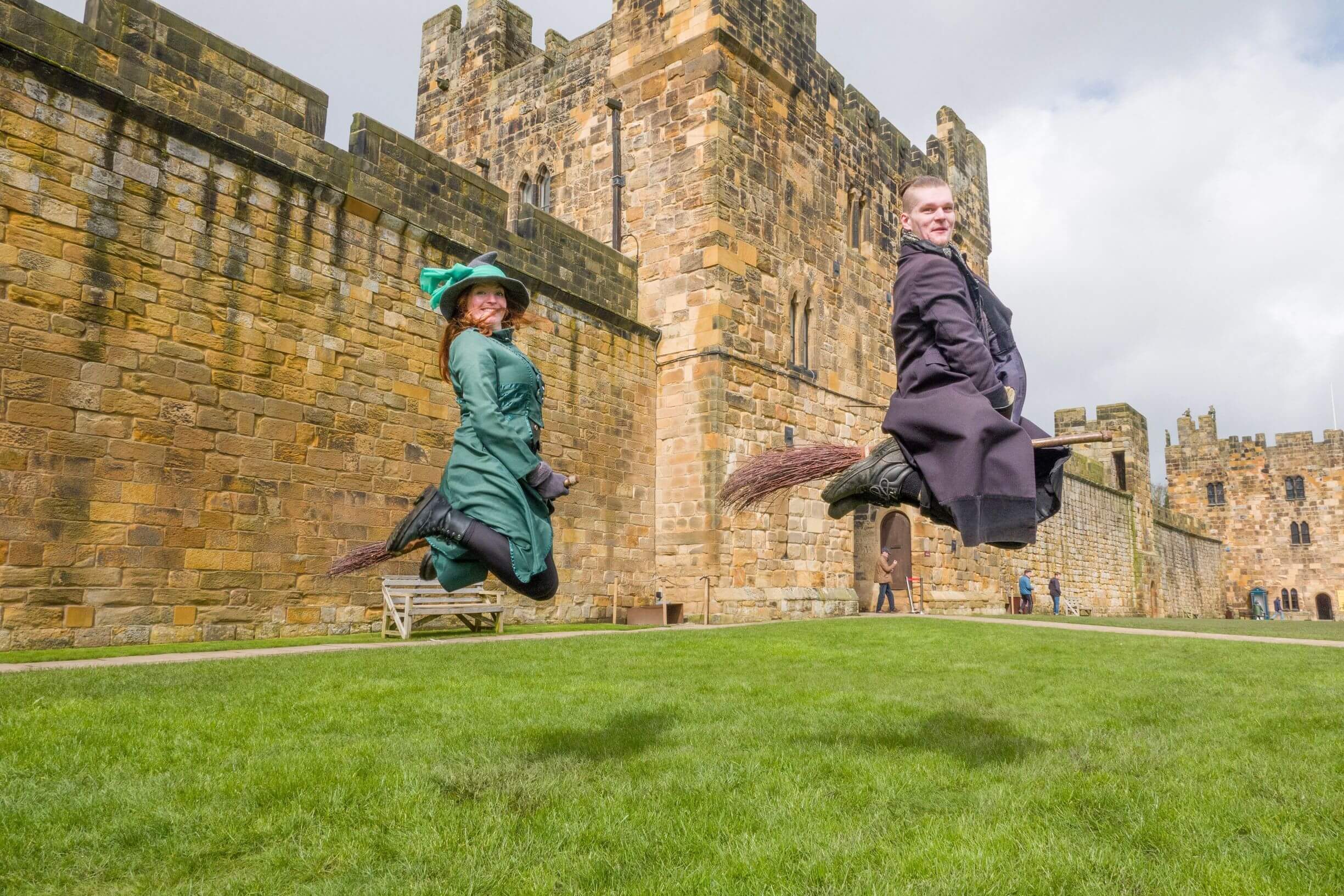 Two wizarding professors demonstrating flying on a broom in the Outer Bailey in Alnwick Castle, Northumberland