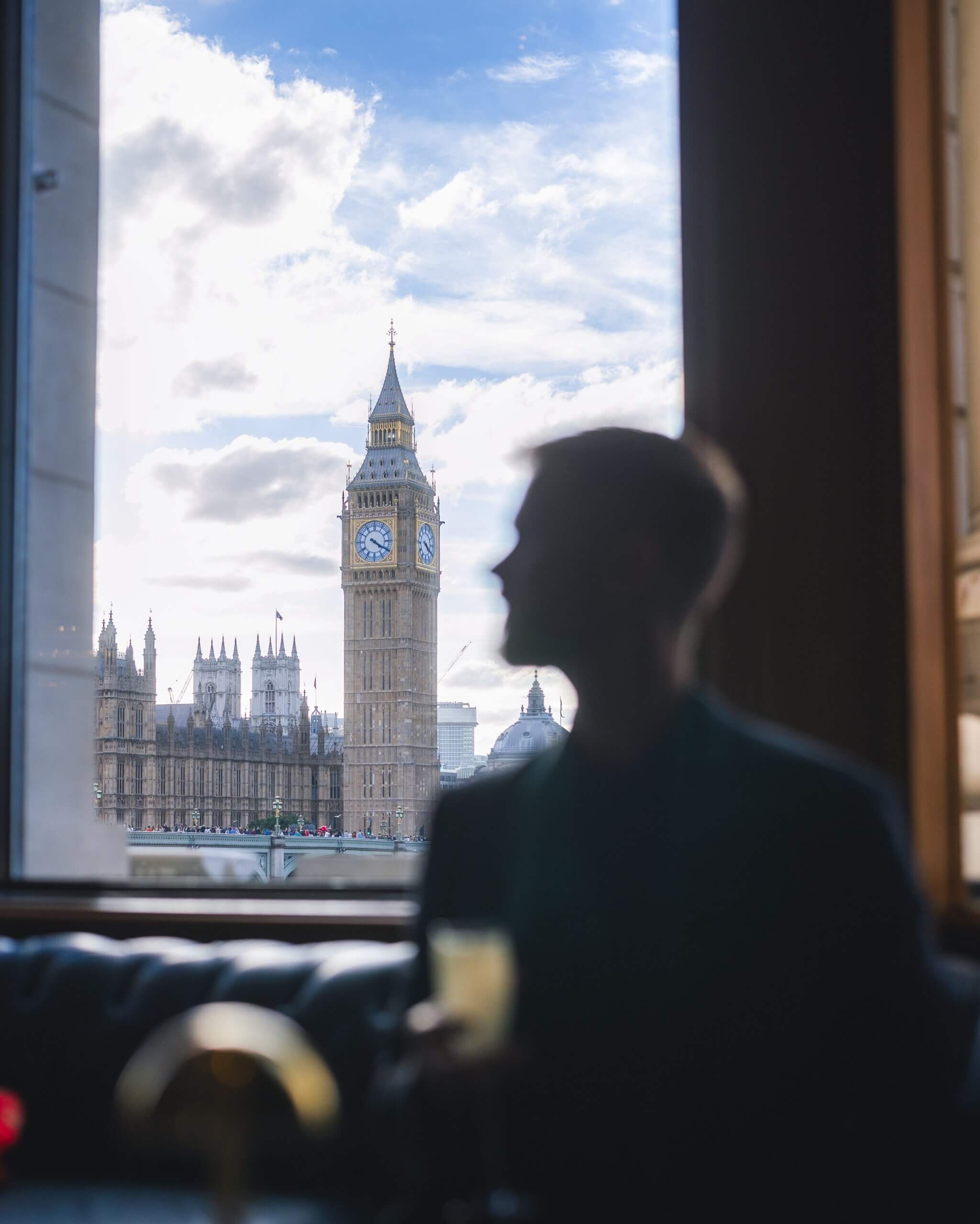 A silhouette of a man in a cafe bar with Big Ben in focus in the background, South Bank, London