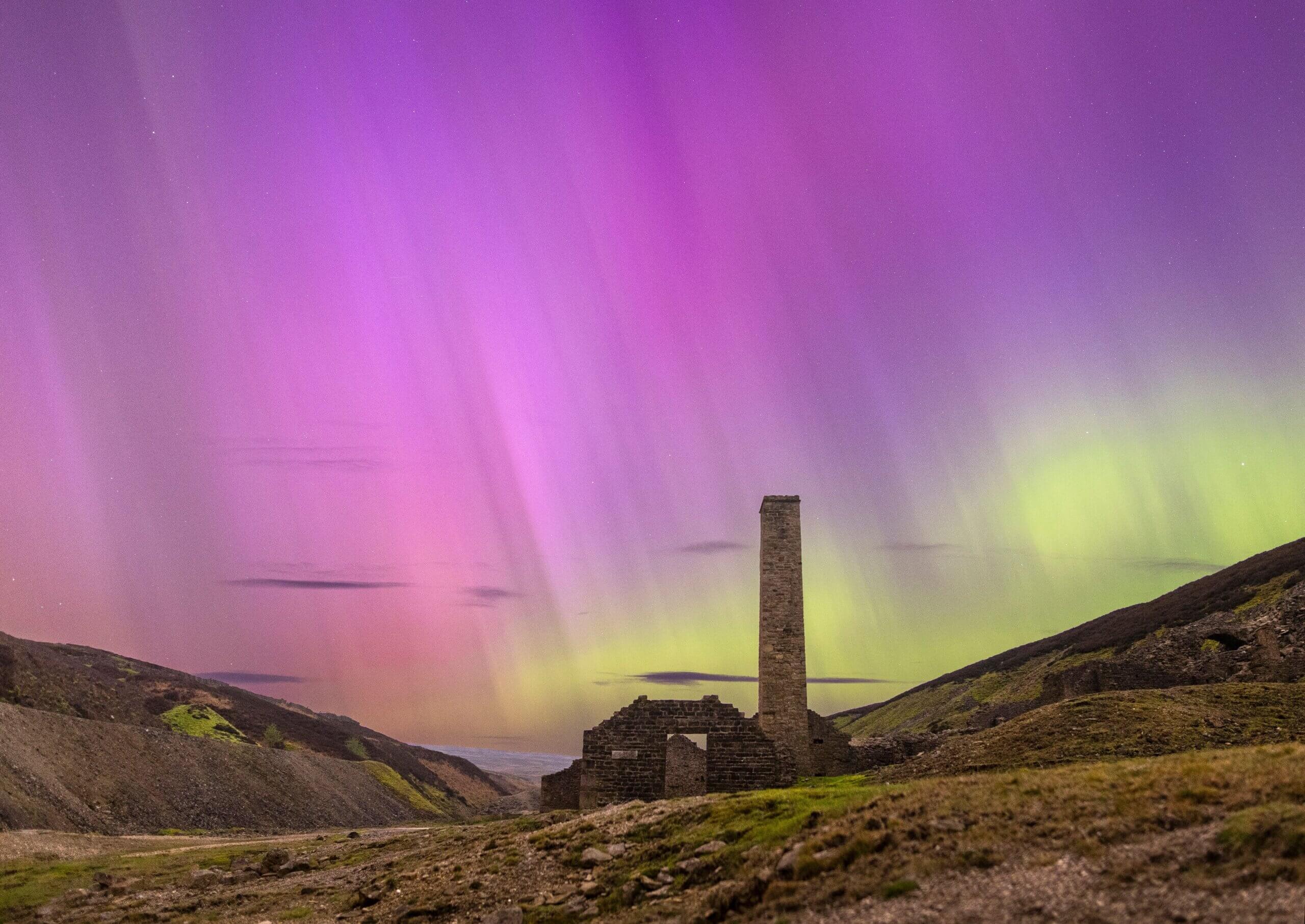 The aurora borealis in the remote countryside by stone house ruins at Old Gang Beck, near Reeth in North Yorkshire, England.