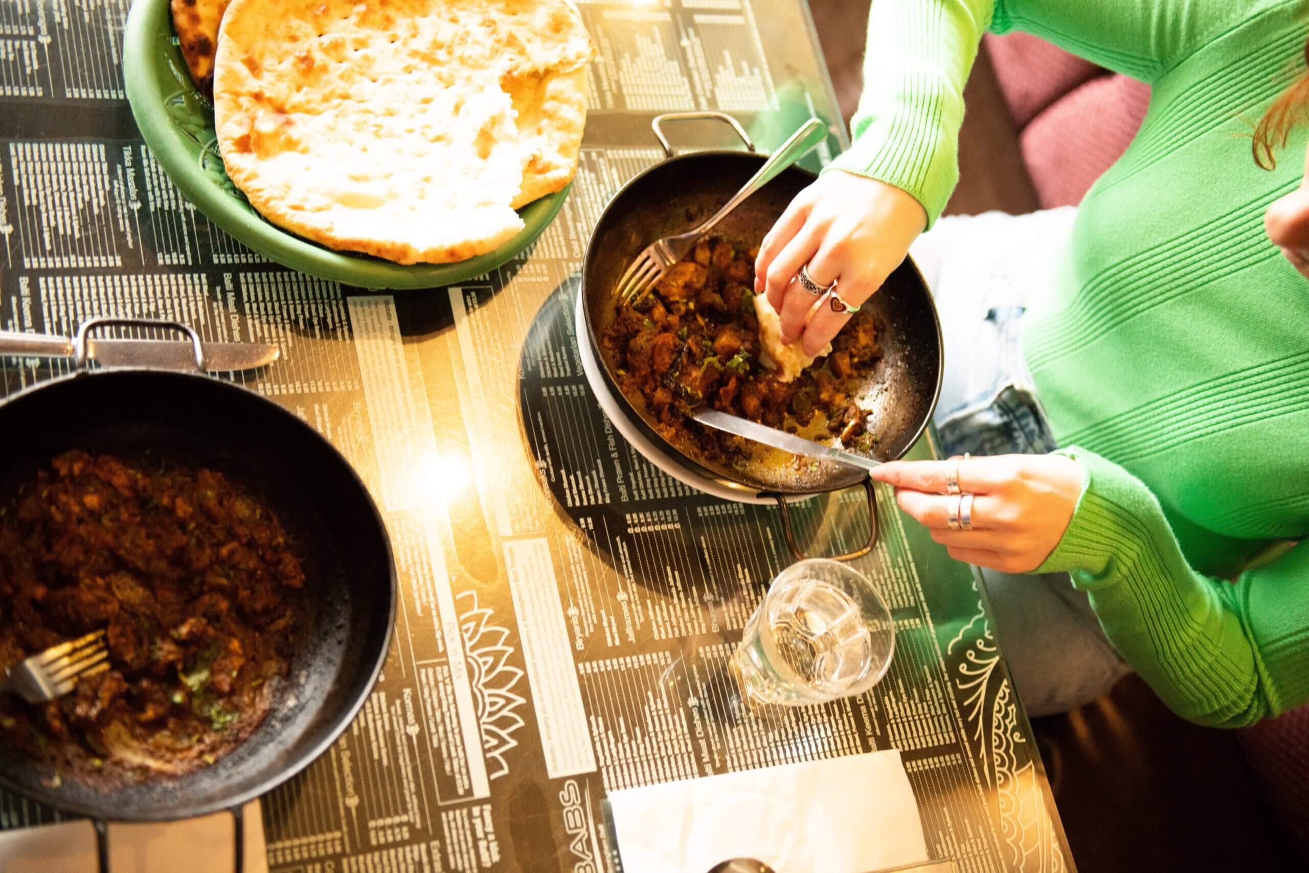 A curry dish and naan bread on the side, served at Shababs restaurant in Birmingham