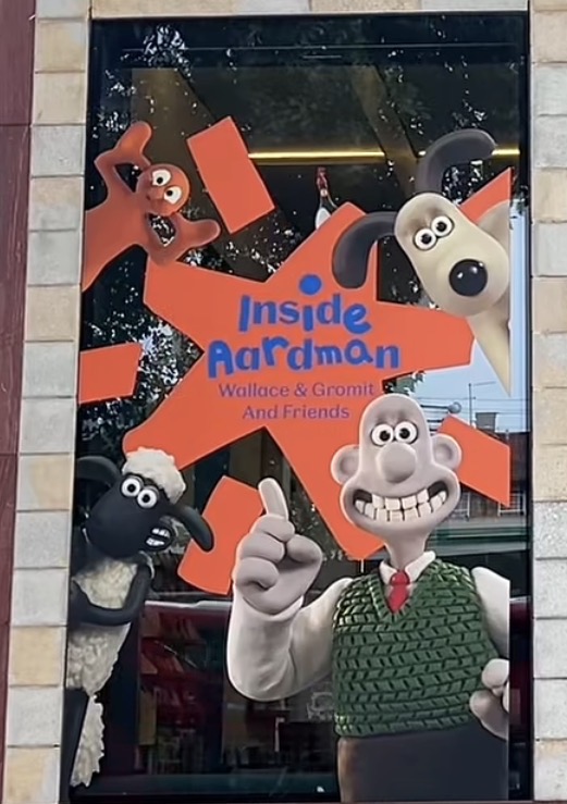 『Inside Aardman: Wallace & Gromit and Friends』のロゴを囲むウォレス、グルミット、ひつじのショーン、モーフのウィンドウディスプレイ