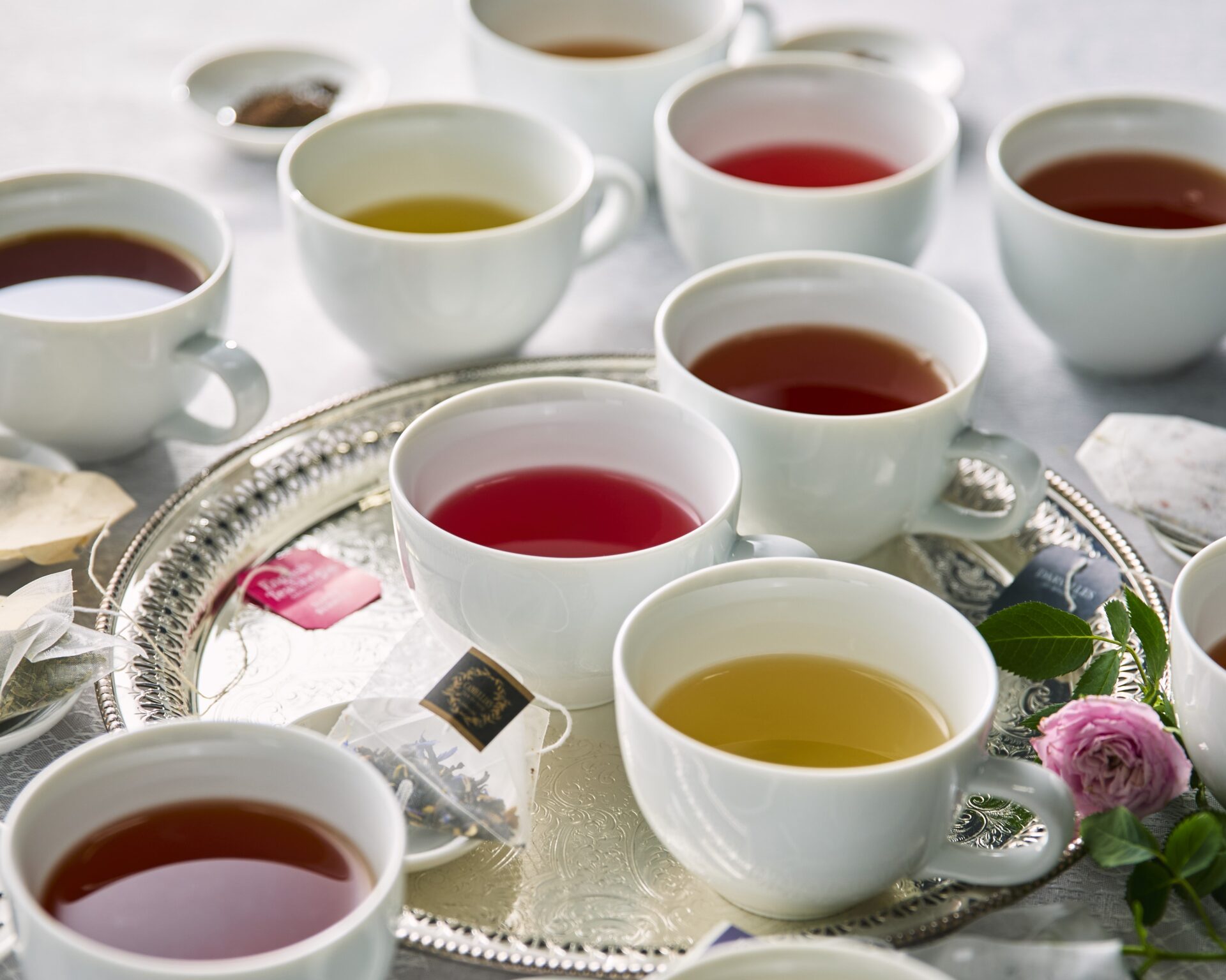 銀盆の上に並ぶ様々な紅茶カップとティーバッグ