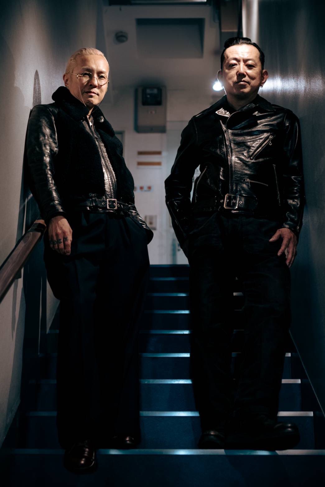 レザージャケットを着用して階段に立つEDDIE-X氏と久保隆一氏