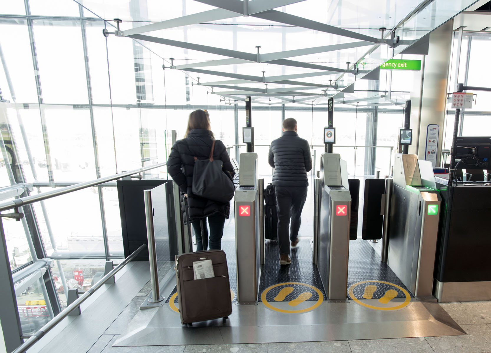 イギリスの空港で自動化ゲートを通過する乗客と手荷物